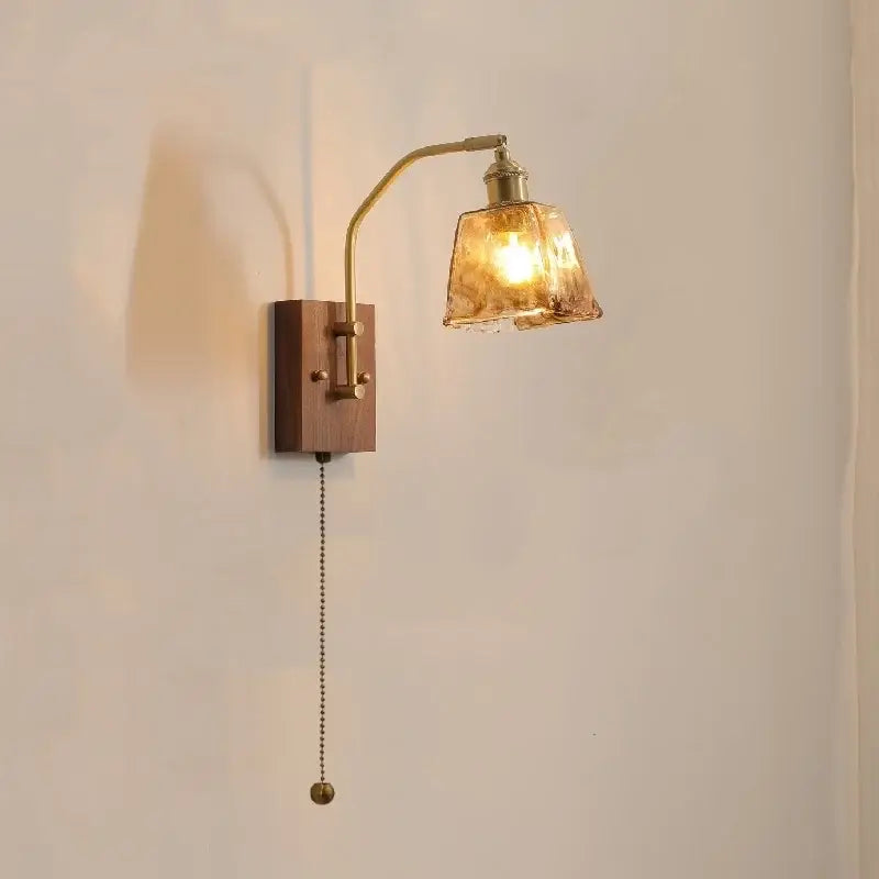 Brass-finished wall lamp with wooden base and amber-tinted textured glass copper led shade for bedroom lighting