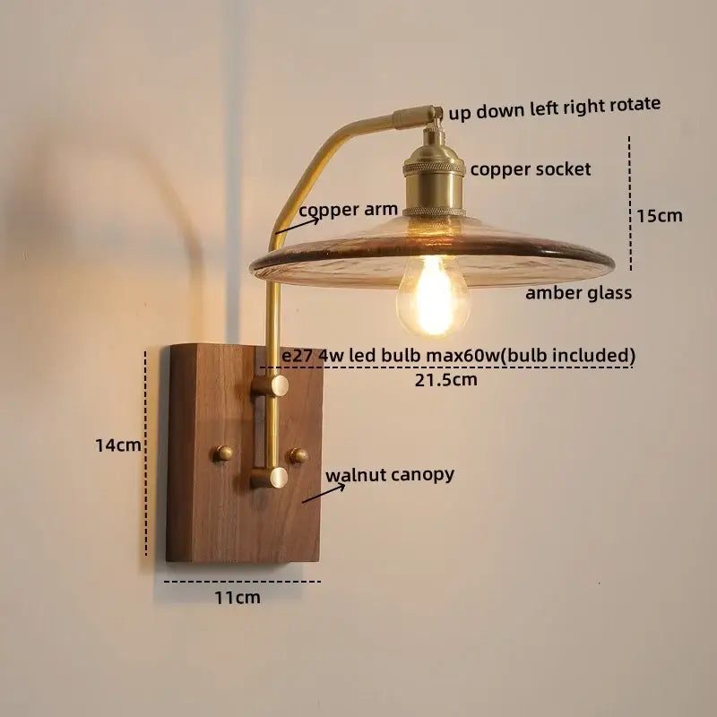 Industrial-style wall lamp with amber glass copper led shade, brass arm, and walnut canopy for modern bedroom lighting