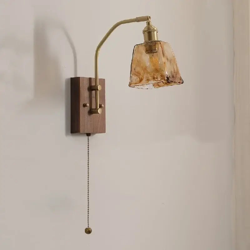 Brass-finished wall lamp with dark wood base and amber textured glass copper led shade for modern bedroom lighting