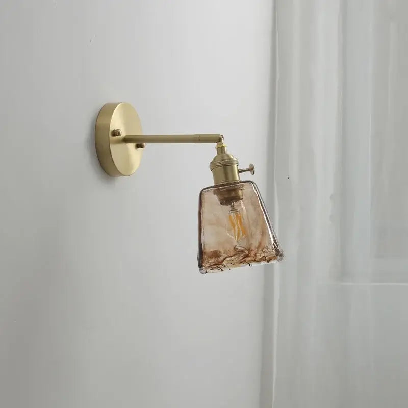 Modern amber glass copper led wall lamp featuring a brass sconce with textured amber glass shade for bedroom use
