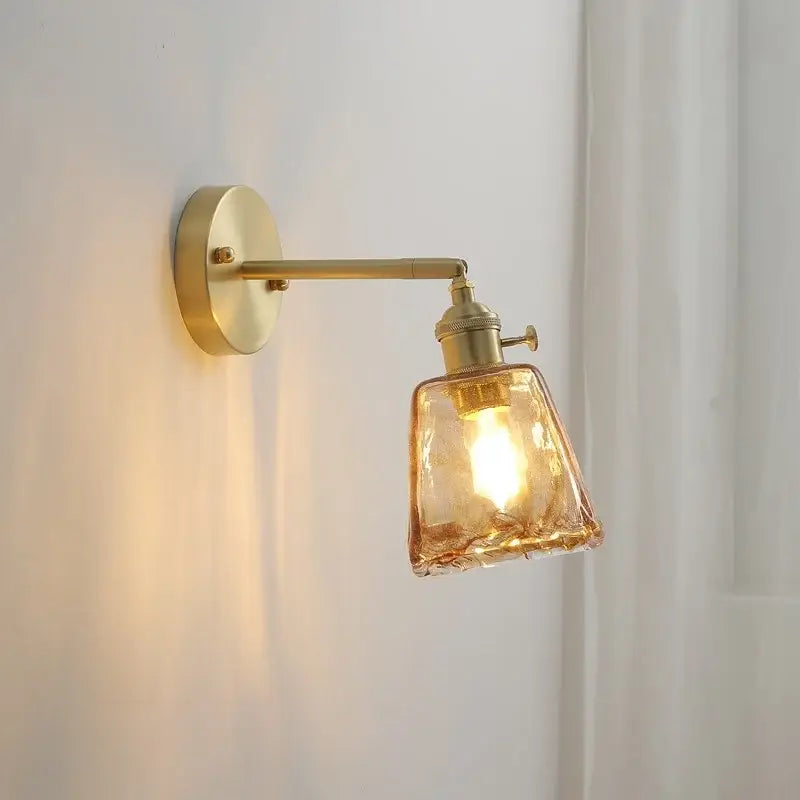 A warm-toned modern amber glass copper led wall lamp with textured shade perfect as a bedroom sconce
