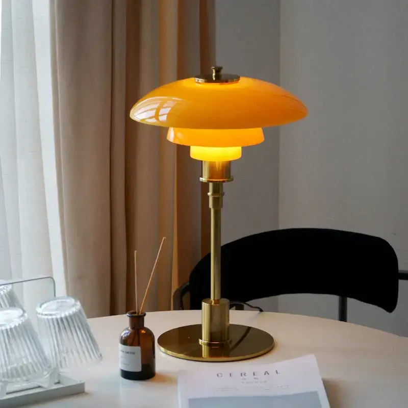 A sleek modern amber glass desk lamp with polished brass base ideal for home office décorbites glass desk lamp