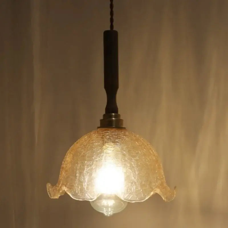 Warm-toned amber glass led pendant lamp with textured fluted design and dark metal suspension for dining room use
