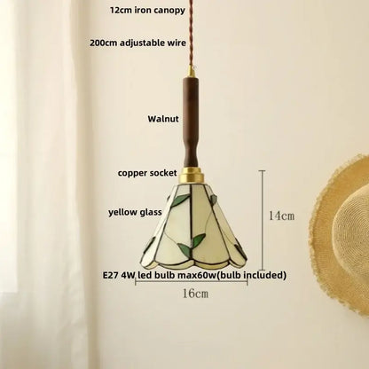 A 14cm decorbites amber glass led pendant light with yellow stained glass and green leaf motifs in walnut wood
