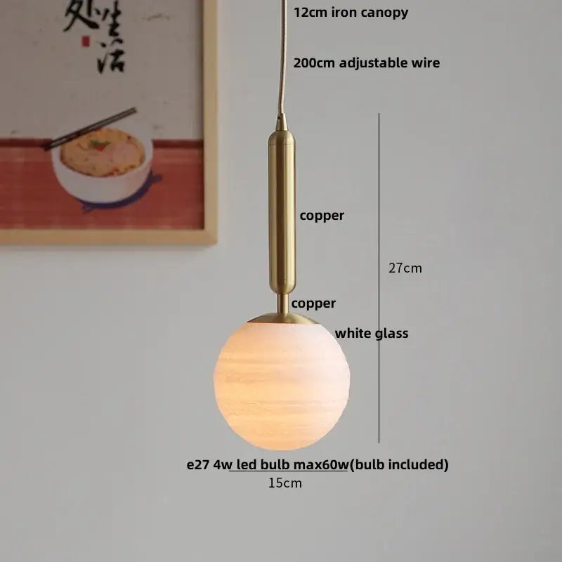 A warm-toned modern amber glass led pendant light with a white glass globe and copper finish for dining room