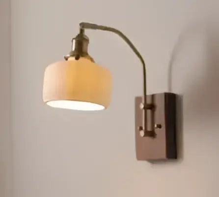 Antique brass wall lamp with a textured off-white fabric shade designed as a modern amber glass led wall lamp sconce