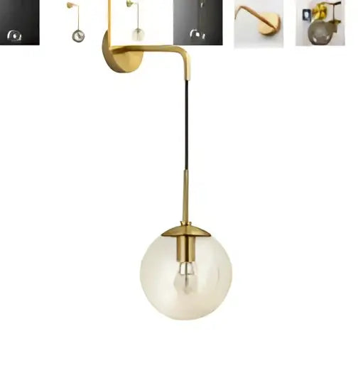 Gold-toned modern amber glass led wall lamp with spherical globe and exposed bulb brass sconce for bedroom use
