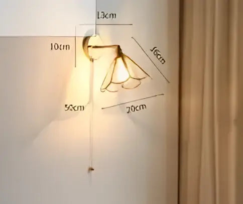 Modern amber glass led wall lamp with two curved shades mounted on a brass-finished bedroom sconce bracket