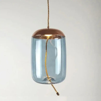 A modern amber glass pendant light with blue body, copper top, and gold cable for decorbites Brokis Knot glass decor