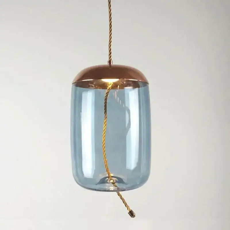 A modern amber glass pendant light with blue body, copper top, and gold cable for decorbites Brokis Knot glass decor