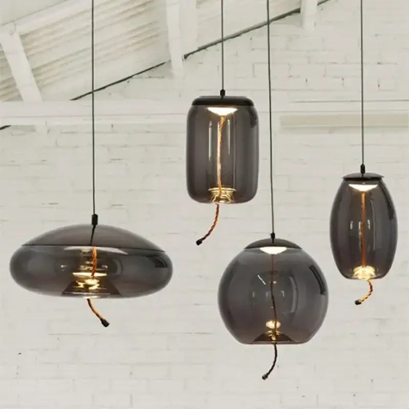 Modern amber glass pendant light with smoked glass and gold accents featuring warm interior glow by decorbites brokis knot glass