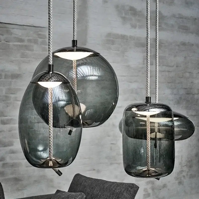 Modern amber glass pendant light with smoked glass, textured rope cords, and gold accents by decorbites brokis knot