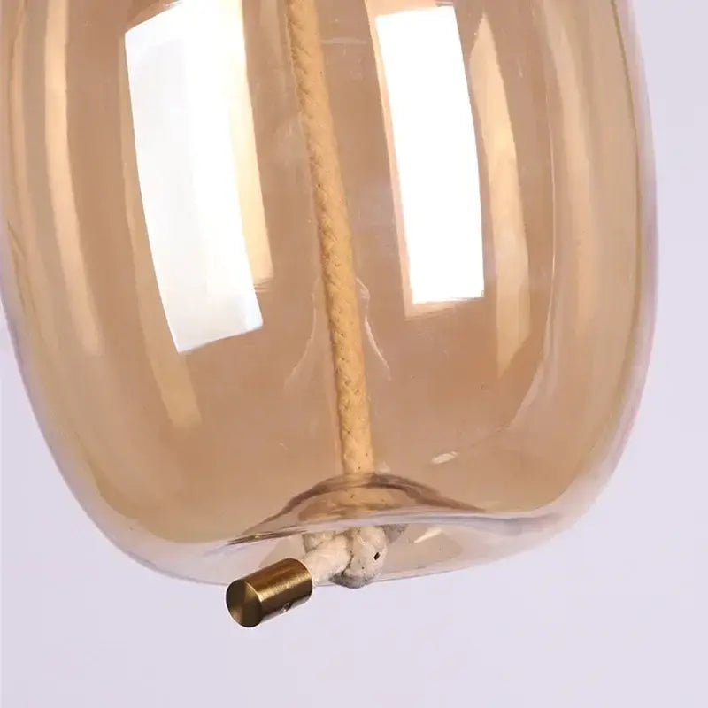 Modern amber glass pendant light with braided rope suspension and brass hardware by decorbites brokis knot glass