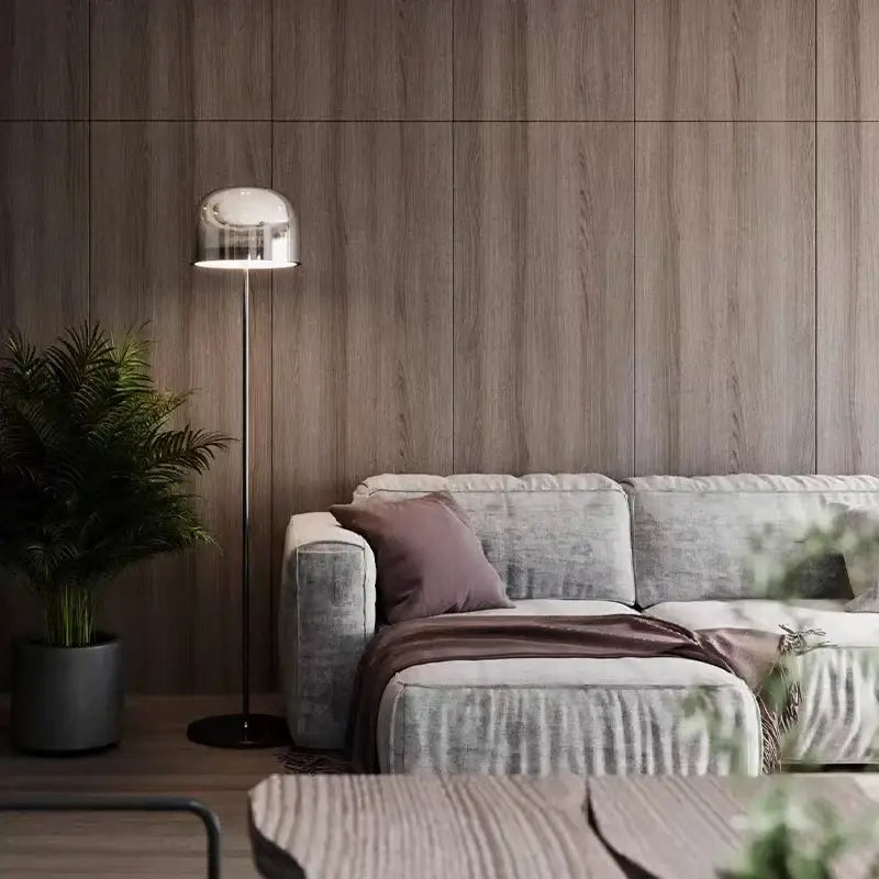 Modern chrome-finished floor lamp with sleek dome-shaped shade complementing amber glass pendant light copper finish