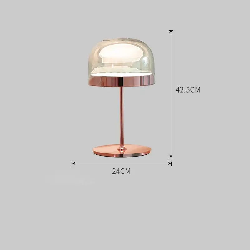 Rose gold metallic table lamp with clear glass dome shade complementing modern amber glass pendant light copper finish