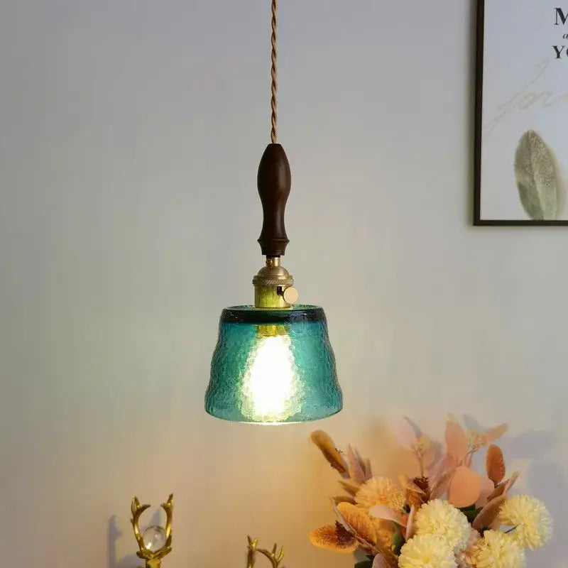 Teal textured glass pendant light with dark wood handle and brass hardware for modern amber pendant light decorbites