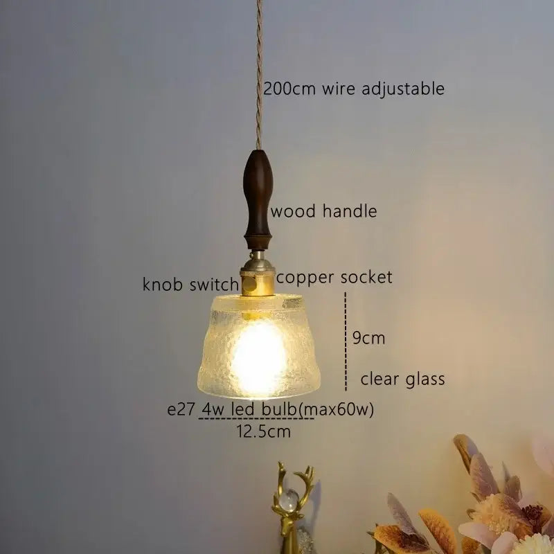 A modern amber pendant light with warm textured glass, dark wood handle, and copper socket for dining room decorbites pendant light
