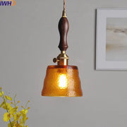 Modern amber pendant light with hammered glass, dark wood handle, and brass accents for dining room decorbites style