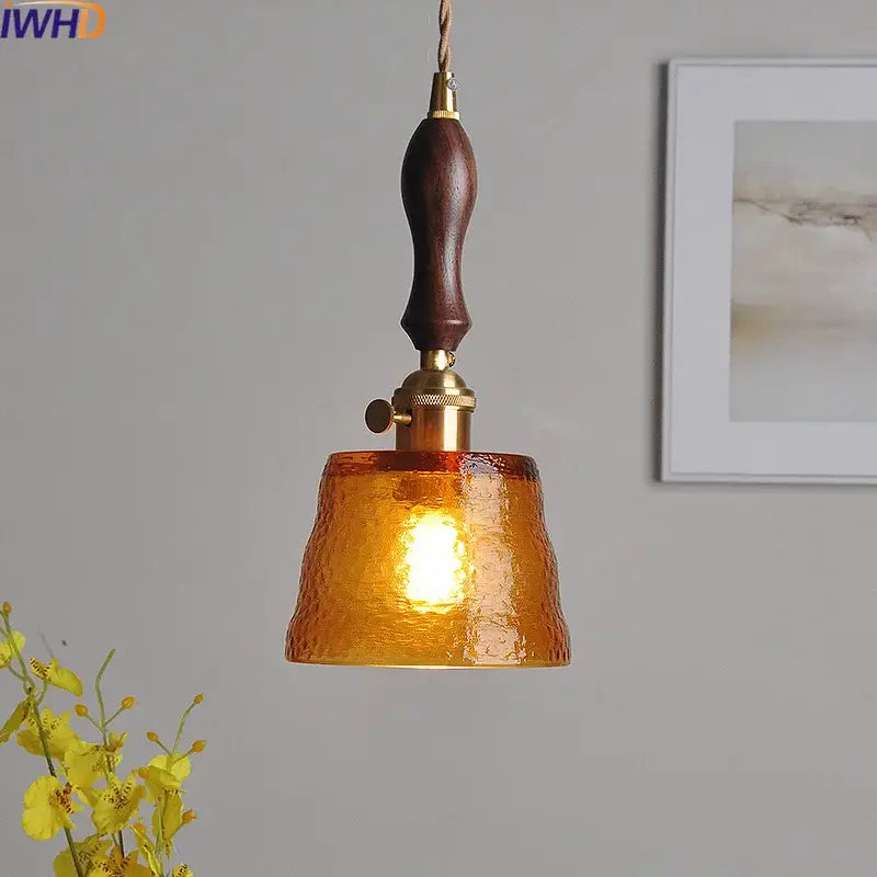 Modern amber pendant light with hammered glass, dark wood handle, and brass accents for dining room decorbites style