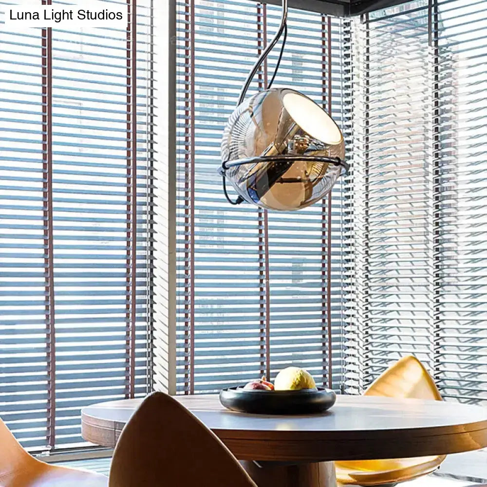 Modern amber glass pendant light set featuring a sleek spherical glass pendant light with chrome and black accents