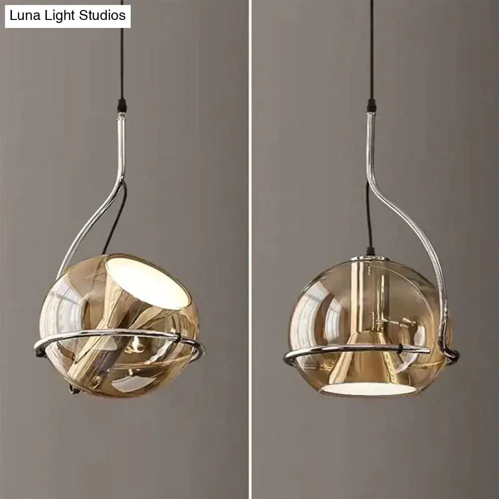 Modern amber glass pendant light with smoked glass globe and chrome metal frame for kitchen lighting
