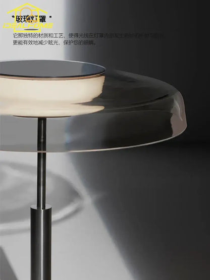 A sleek modern amber glass table lamp with translucent shade and polished base for red and gray bedroom decor by decorbites dora glass