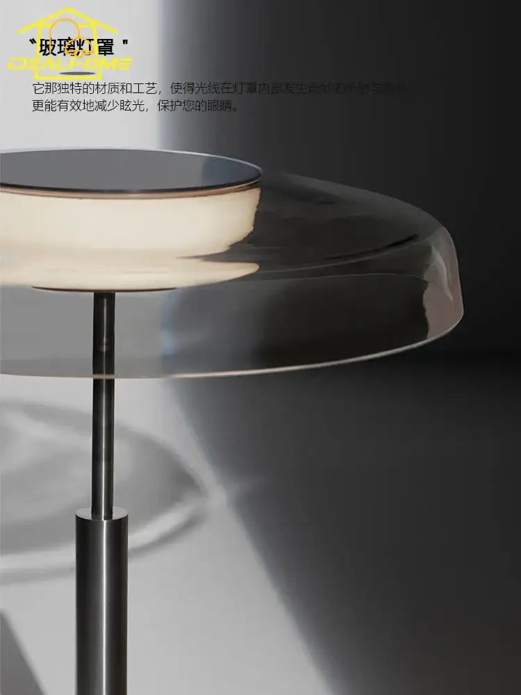 A sleek modern amber glass table lamp with translucent shade and polished base for red and gray bedroom decor by decorbites dora glass