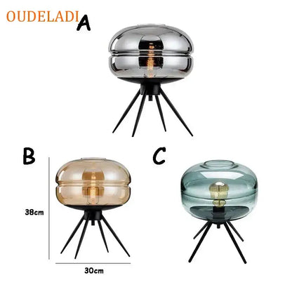 Modern amber glass table lamp with sleek dome-shaped shade and black tripod base for stylish bedroom decor