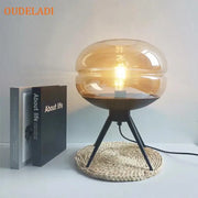 Modern amber glass table lamp with black tripod base featuring exposed bulb for stylish bedroom decorbites glass table lamp