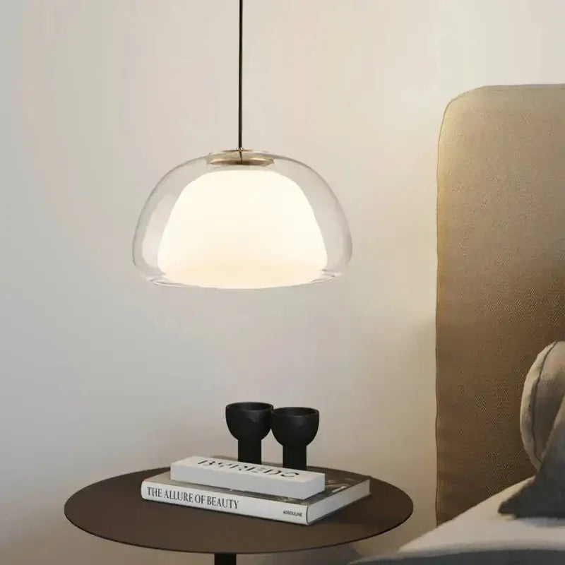 Modern amber and gray glass pendant light with clear glass dome and brass-toned fixture for dining room