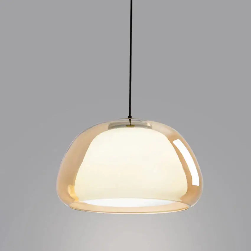 A sleek dome-shaped modern amber glass pendant light with black cord for dining room use