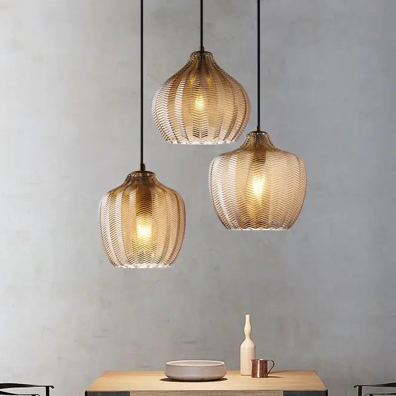 Three hanging pendant lights with amber gray glass shades and wavy textured design for modern dining room decorbites decor
