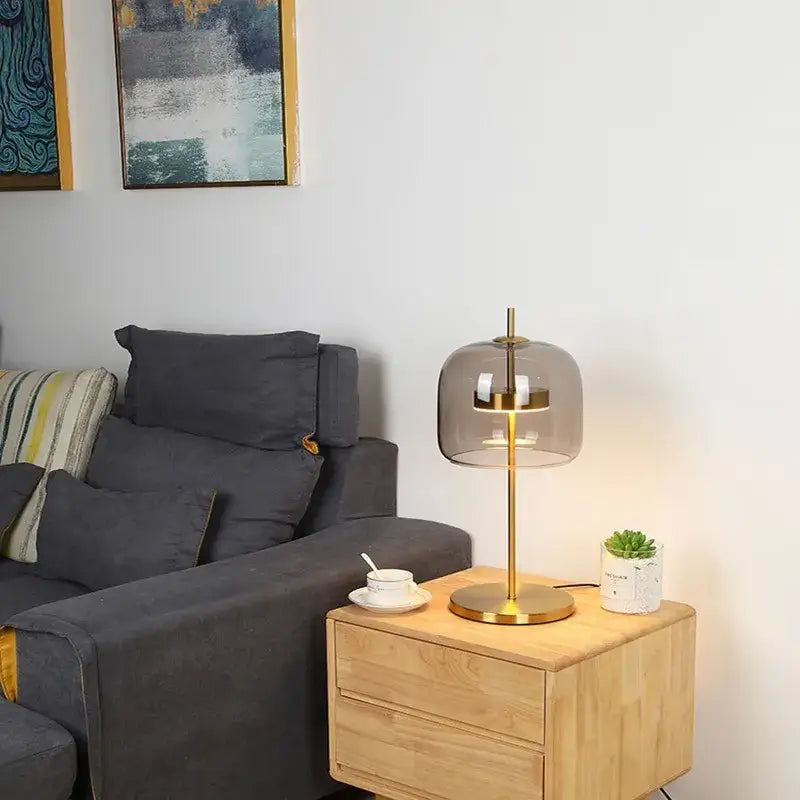 Modern brass decorbites glass table lamp with translucent gray dome and circular led light for bedroom decor