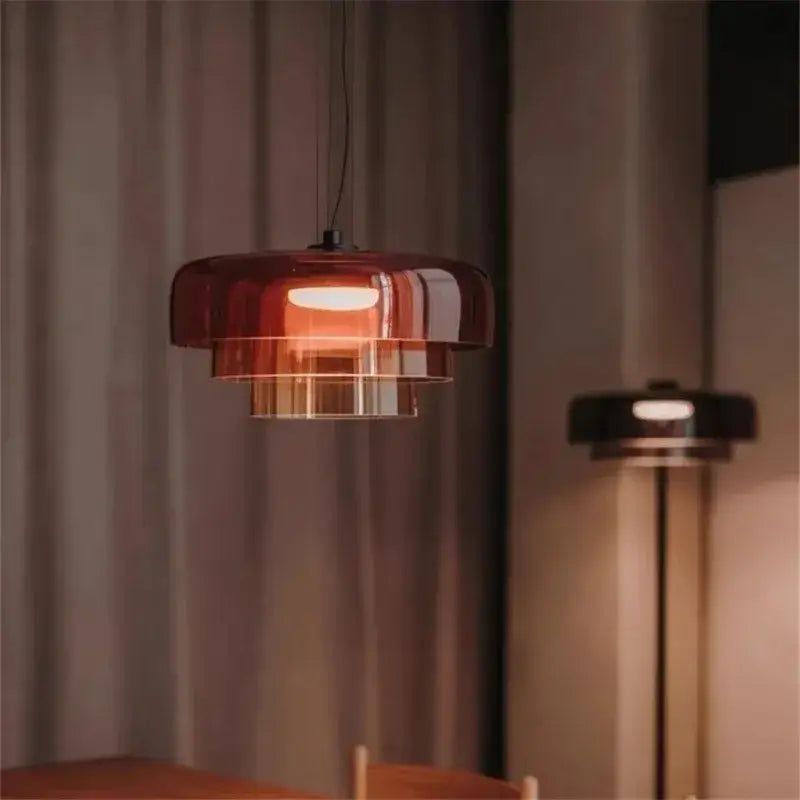 A modern pendant light with layered translucent amber glass and black metal frame ideal for dining room decorbites levels colorful glass