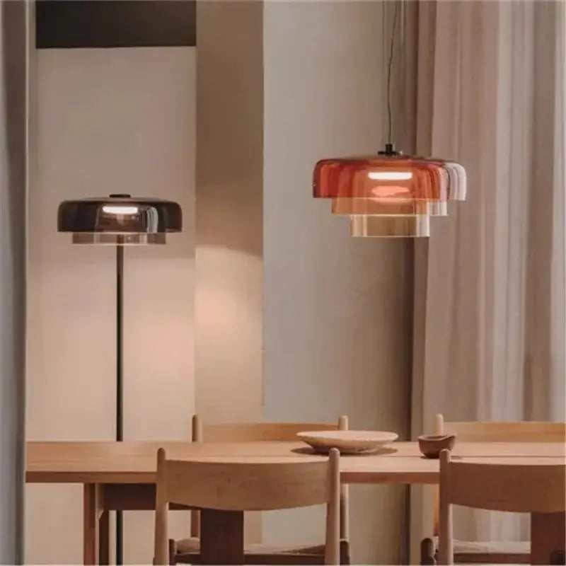 Modern amber layered glass pendant light with warm translucent rings suspended from black cord for dining room decorbites levels colorful glass