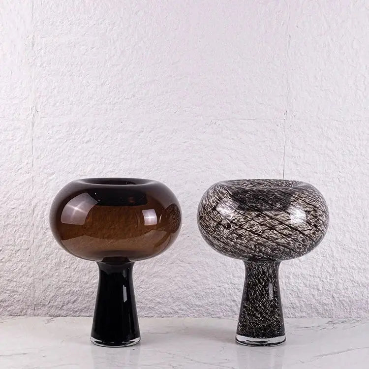 Two geometric glass vases with amber and black white marble design on marble surface for flower arranger decorbites