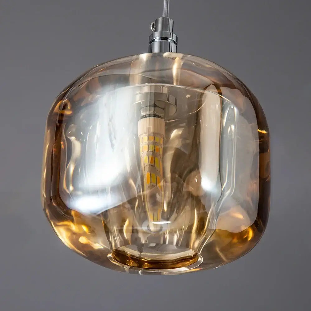 Modern amber and smoke crystal staircase chandelier featuring an amber-tinted glass pendant with visible led bulb