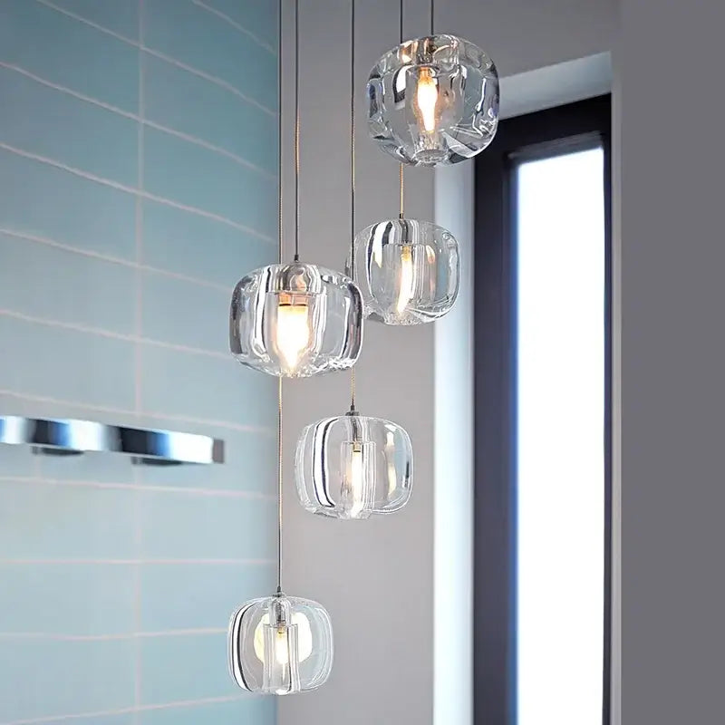 Modern amber and smoke crystal staircase chandelier with clear faceted glass pendant lights and warm glowing bulbs