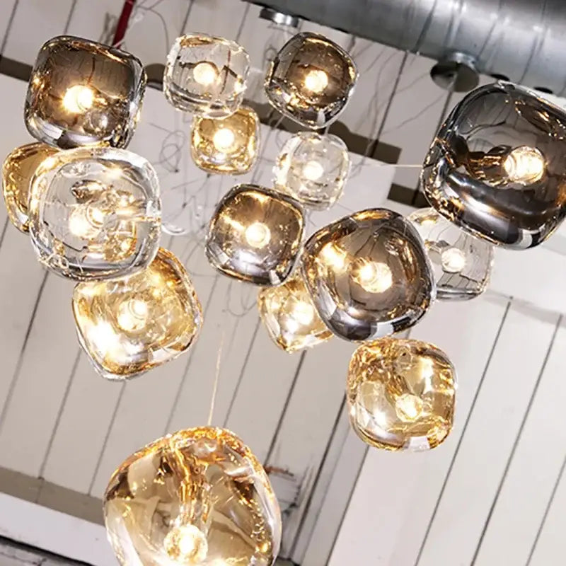 A modern amber and smoke crystal staircase chandelier with irregular translucent glass orbs for living room use