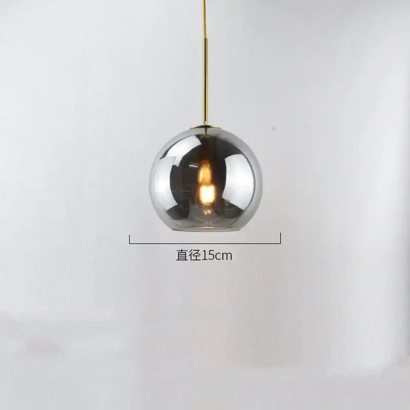 A sleek 15cm chrome glass ball led pendant light with gold-toned chain for modern dining room decorbites decor
