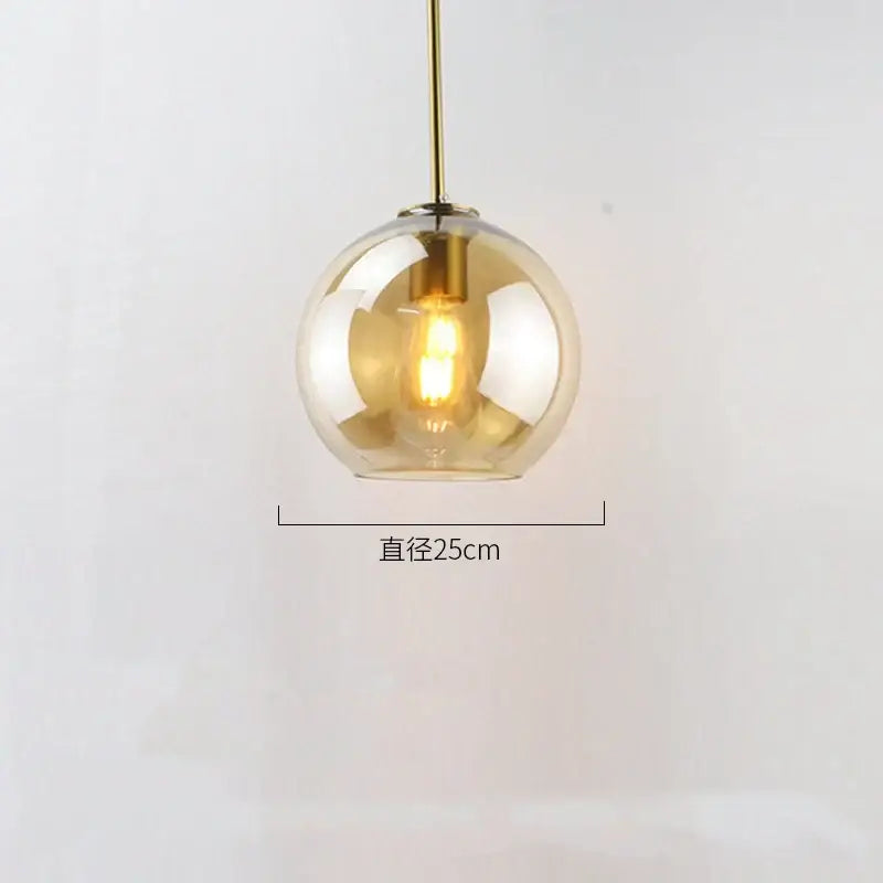 Modern amber smoked gray and clear glass ball led pendant light with warm brass finish and exposed filament bulb for dining room decorbites glass ball
