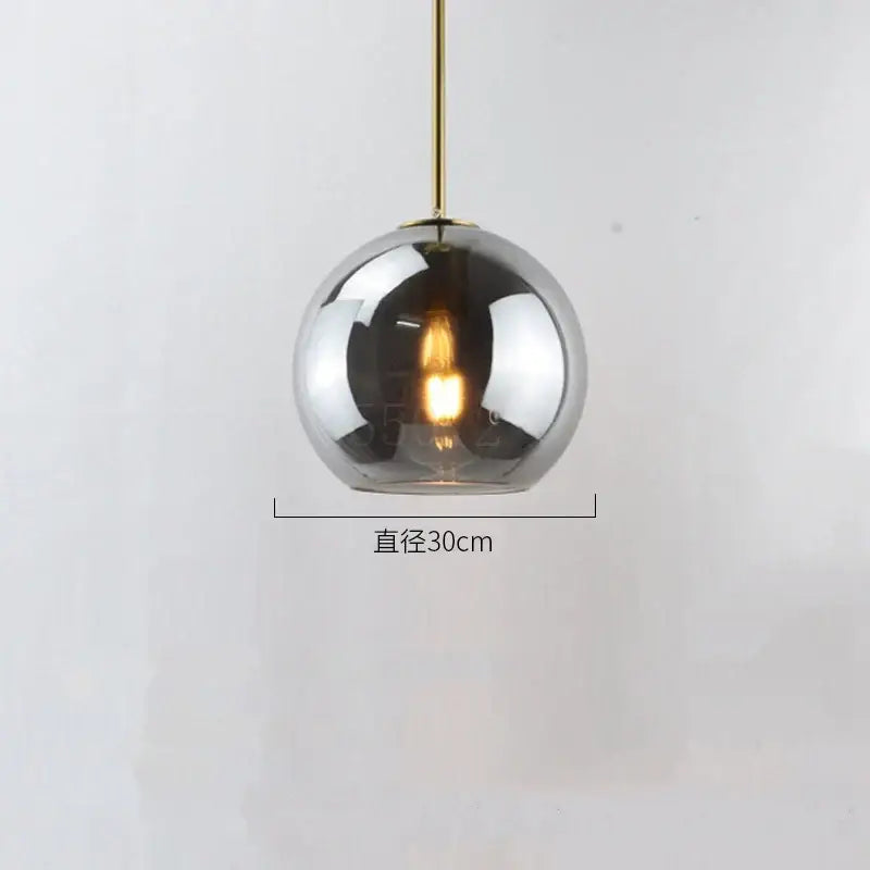 A sleek 30cm modern glass ball led pendant light with amber smoked gray globe and brass rod for dining room decorbites
