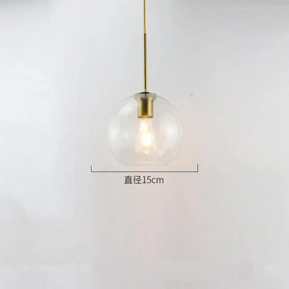 A sleek modern amber smoked gray and clear glass ball led pendant light with brass fixture for dining room decorbites glass ball