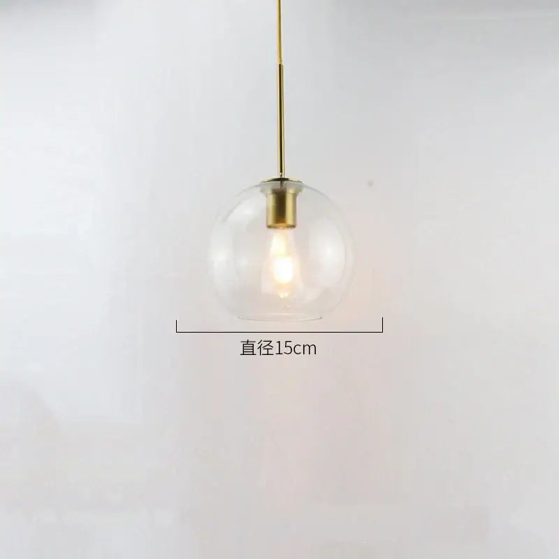 A sleek modern amber smoked gray and clear glass ball led pendant light with brass fixture for dining room decorbites glass ball