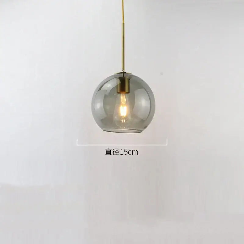 A sleek 15cm amber smoked glass ball led pendant light with brass fixture for modern dining room decorbites pendant lights