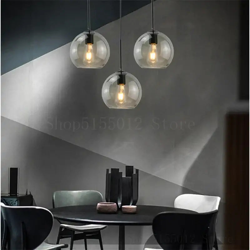 Three clear glass ball led pendant lights with exposed filament bulbs hang from black cords for dining room decorbites glass ball lighting