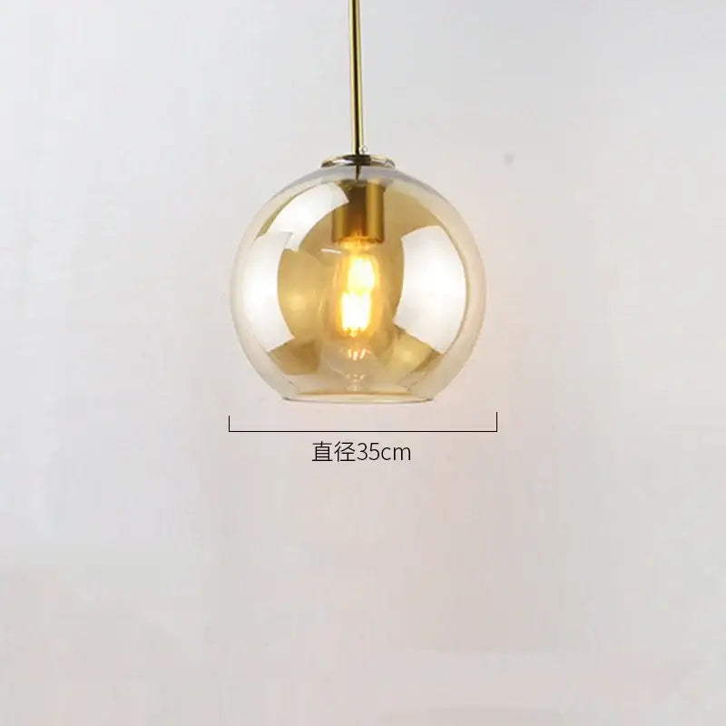 Modern amber glass ball led pendant light with brass rod and exposed filament bulb for dining room decorbites glass ball