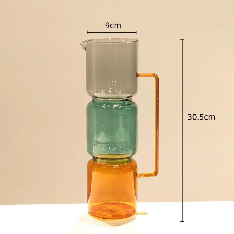 A modern three-tiered glass pitcher with double glazing stained amber and teal sections for living room decor