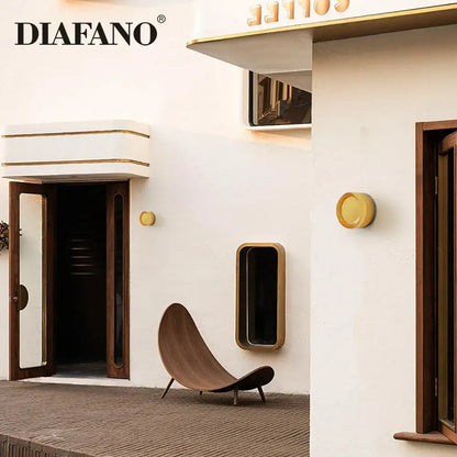 Modern wooden lounge chair with curved design and dark brown finish next to a modern amber and white glass sconce led wall lamp