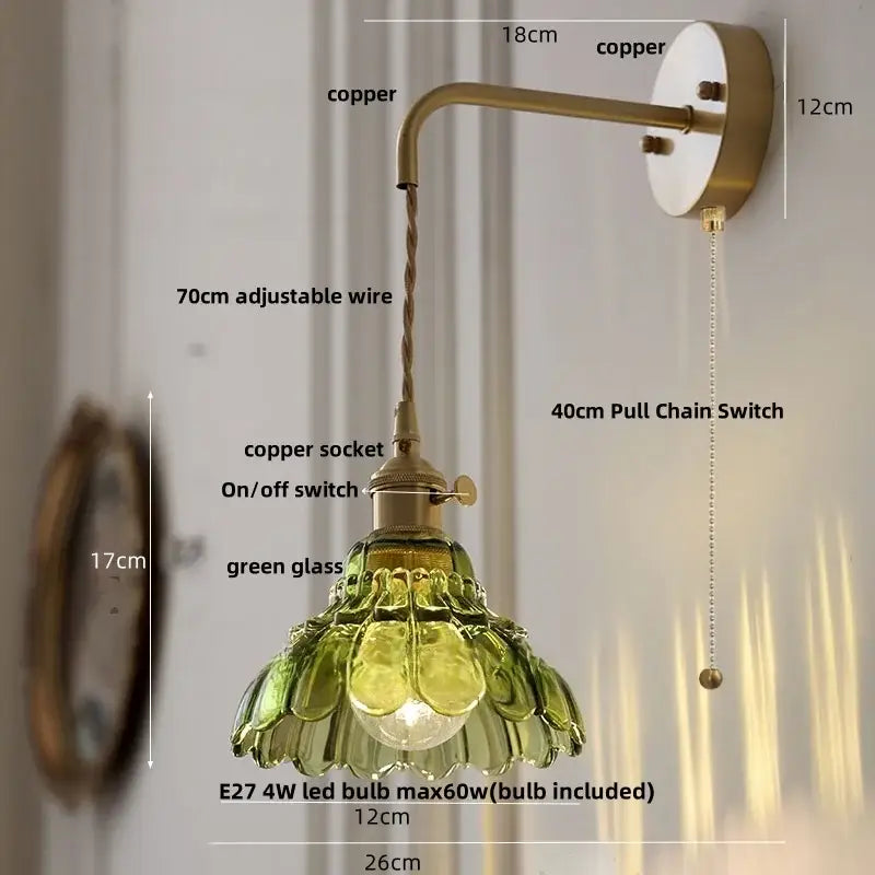 Vintage-style copper wall light with a green decorbites amber glass shade shaped like overlapping petals for bedroom use